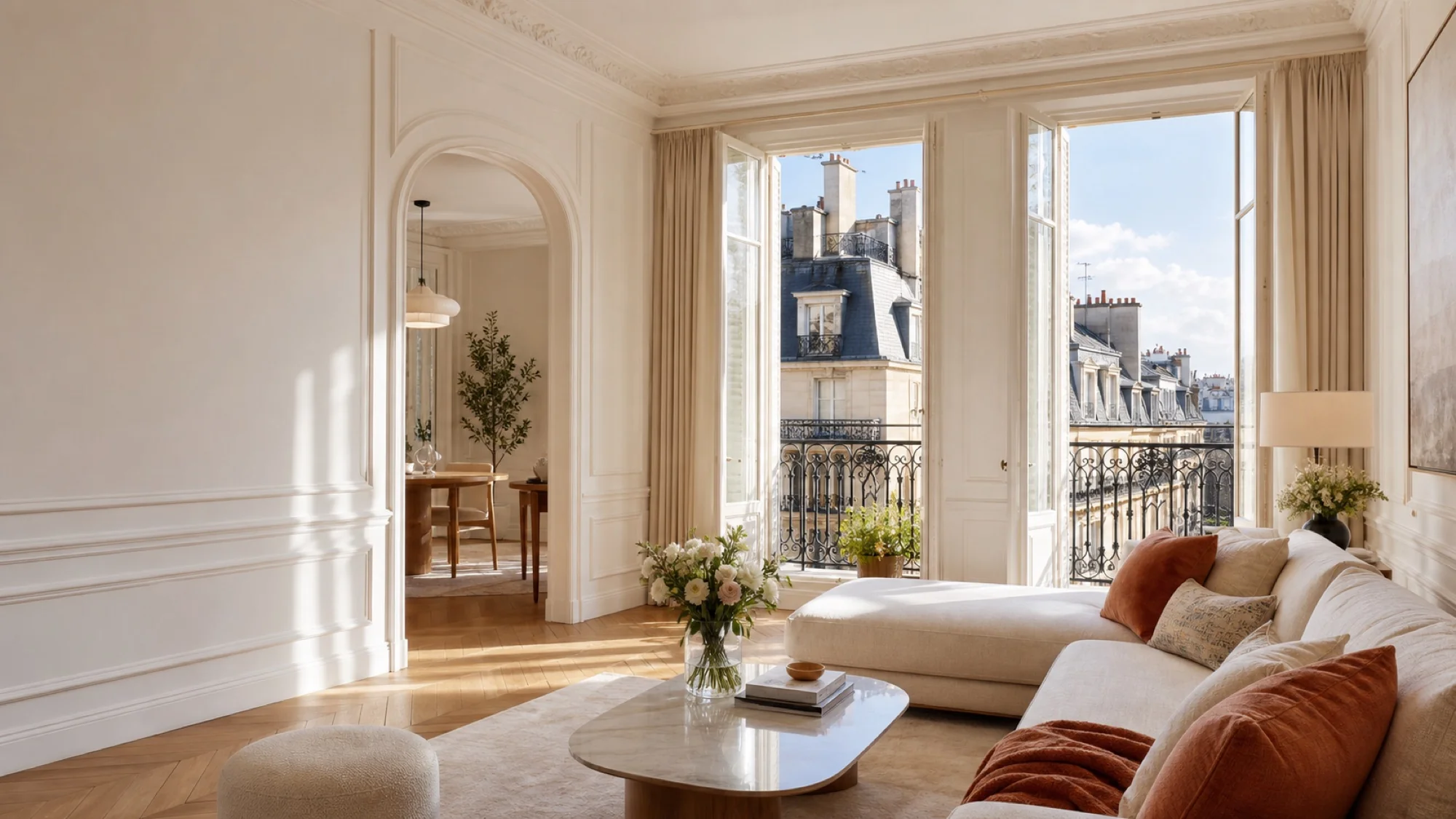 Salon haussmannien lumineux avec balcon filant et vue sur les toits de Paris, parquet en point de Hongrie