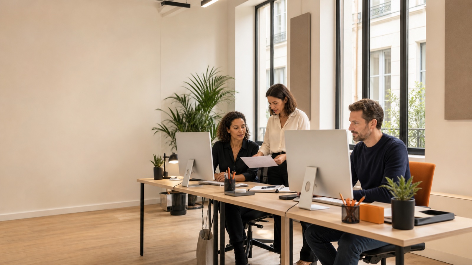 Trois membres de l'équipe Ell'a Services travaillent dans un open space moderne à Paris 11e